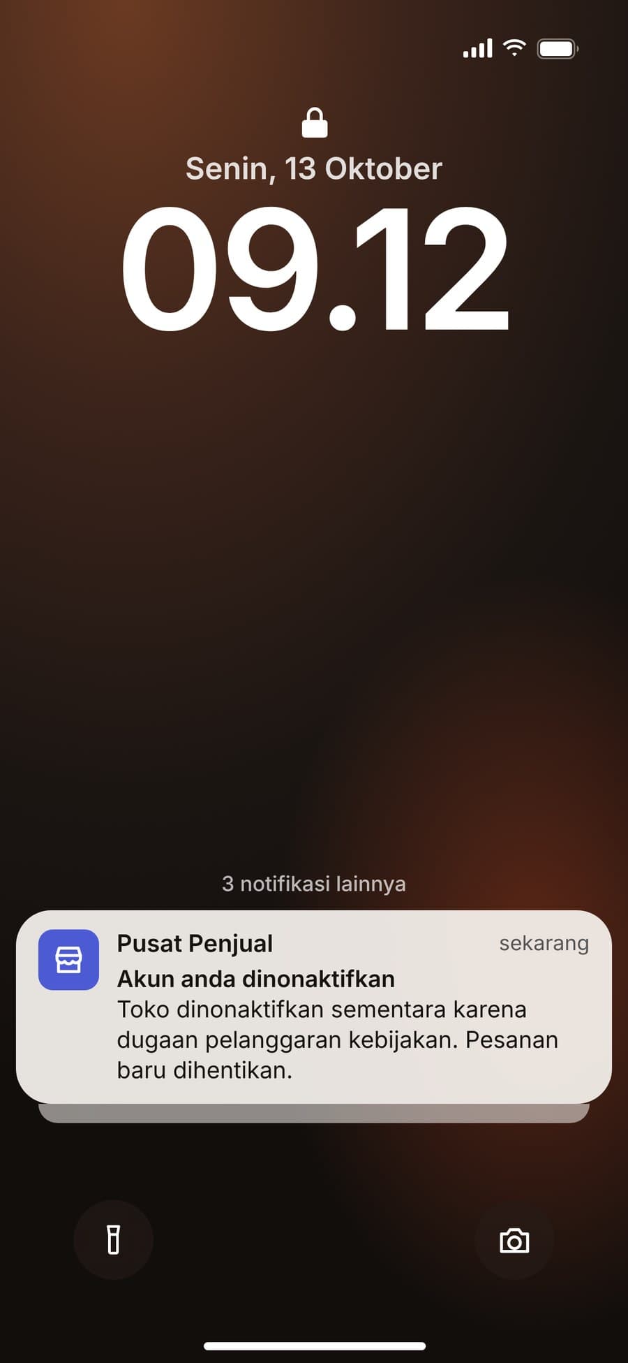Layar kunci ponsel pukul 09.12 dengan notifikasi: Akun anda dinonaktifkan, pesanan baru dihentikan